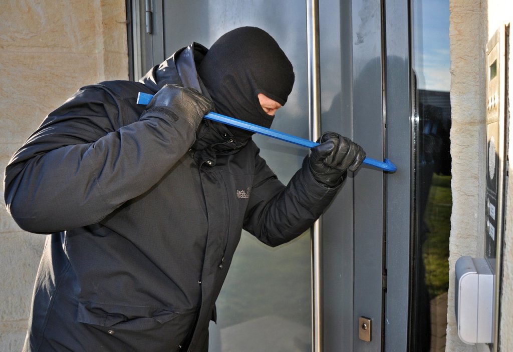 Man in balaclava, burglar, trying to break into a house. Image by Steffen Salow from Pixabay.